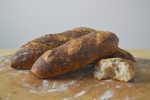 Finished Artisan Demi Baguette Loaves on Wooden Cutting Board
