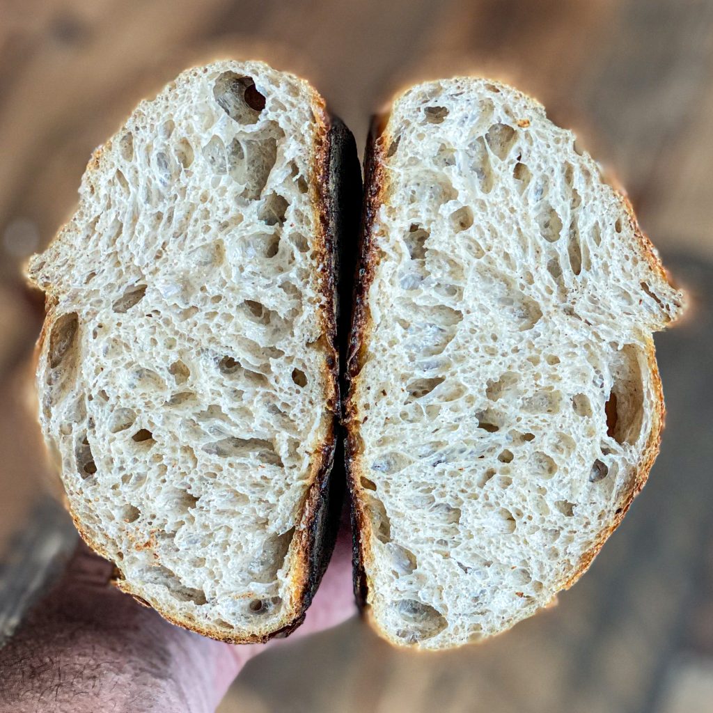 sourdough loaf cut in half to show the open crumb