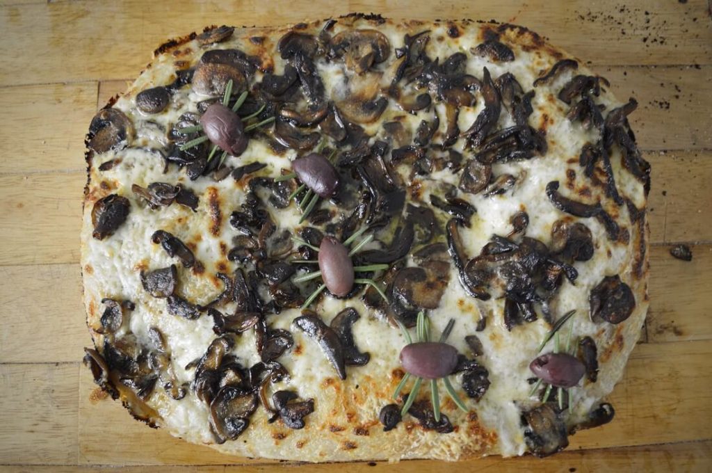 Finished mushroom pan pizza with olive and rosemary spiders